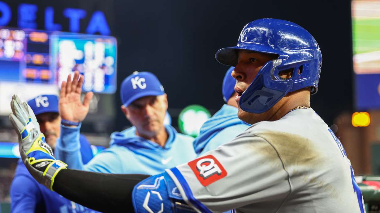 Kansas City Royals' Salvador Perez high-fives teammates in the dugout after hitting a solo home run in the seventh inning of a baseball game against the Atlanta Braves, Saturday, March 28, 2026, in Atlanta.