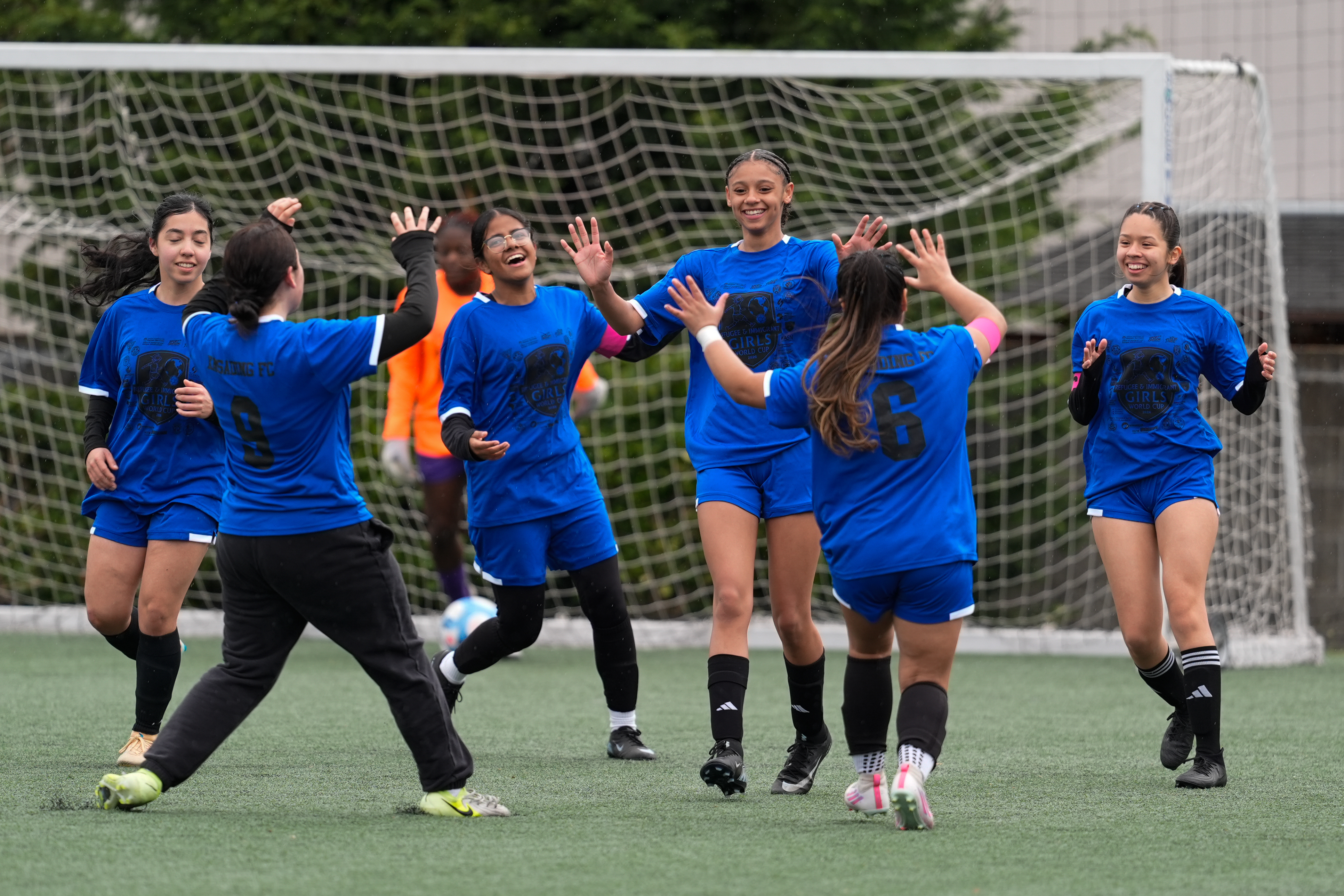 Aubrey Decraig, third from right, celebrates with teammates after scoring a goal during a soccer tournament for immigrant and refugee girls on Sunday, March 29, 2026, in Portland, Ore.