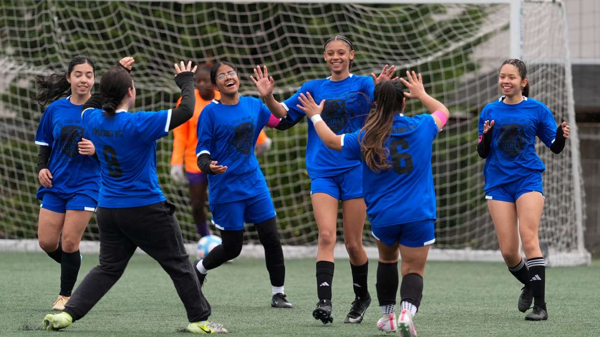 Aubrey Decraig, third from right, celebrates with teammates after scoring a goal during a soccer tournament for immigrant and refugee girls on Sunday, March 29, 2026, in Portland, Ore.