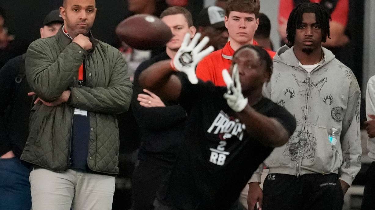 Ian Cunningham, general manager of the Atlanta Falcons, left, watches players work out during the school's NFL football pro day, Wednesday, March 18, 2026, in Athens, Ga.