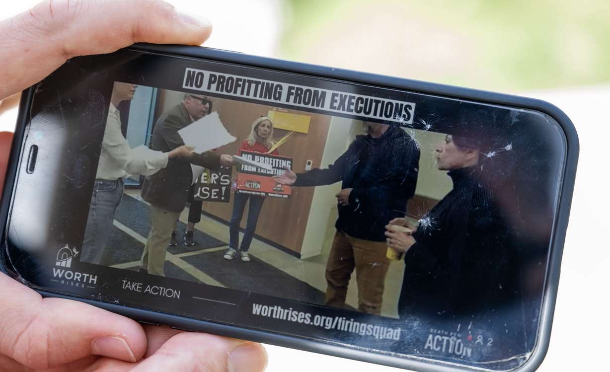 Viewed from a live view on a cellphone, officials from Okland Construction are handed a petition and a letter by a small group gathered in Salt Lake City on Monday to express their concerns about Okland’s involvement in the construction of a building that will be used for executions at the Idaho State Prison.