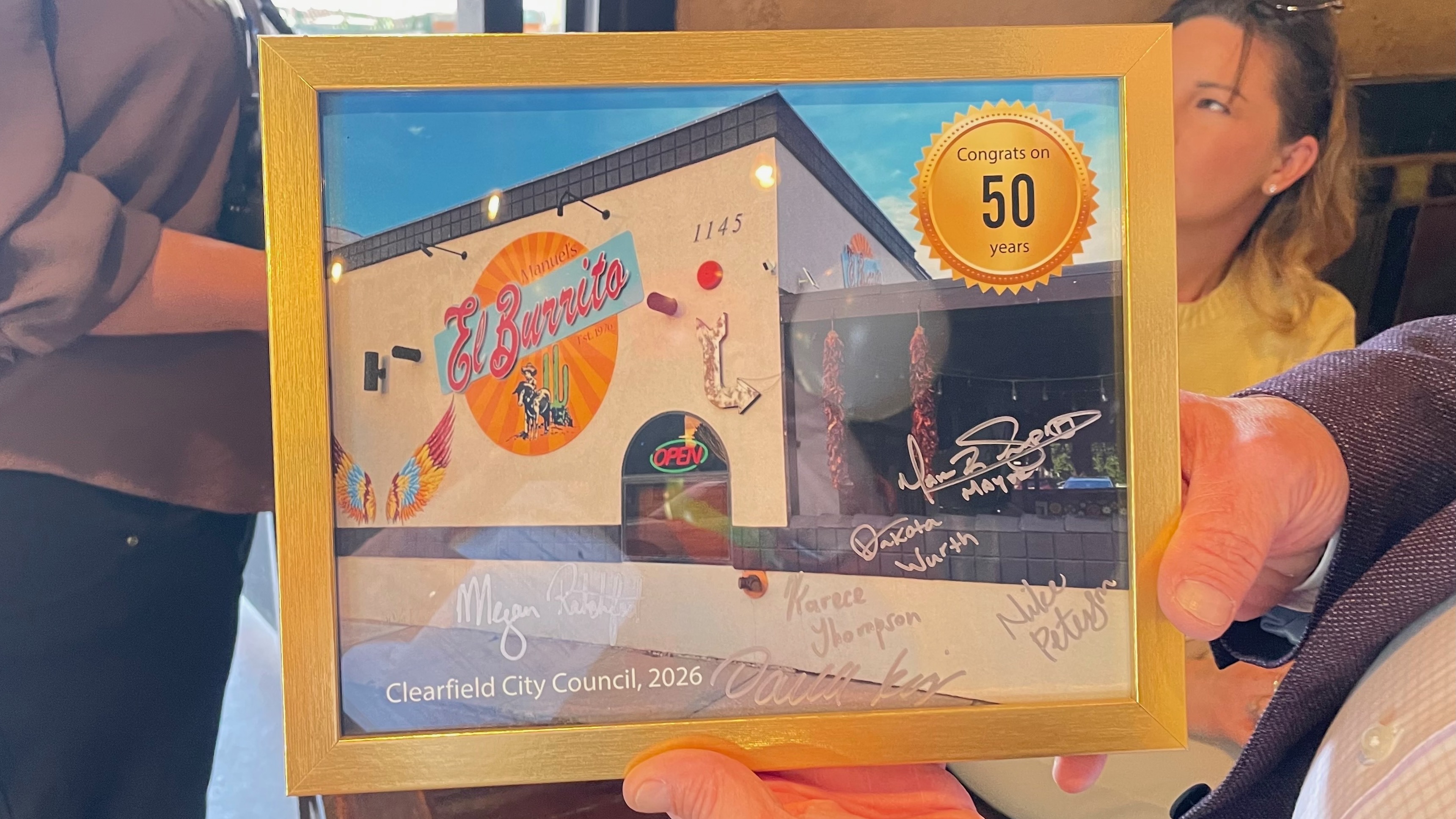 The operators of Manuel's El Burrito in Clearfield held a small celebration to mark 50 years in business for the Clearfield Mexican restaurant. Clearfield Mayor Mark Shepherd holds a memento he gave to operators Manuel Gallegos Jr. and his son Alec to mark the occasion.