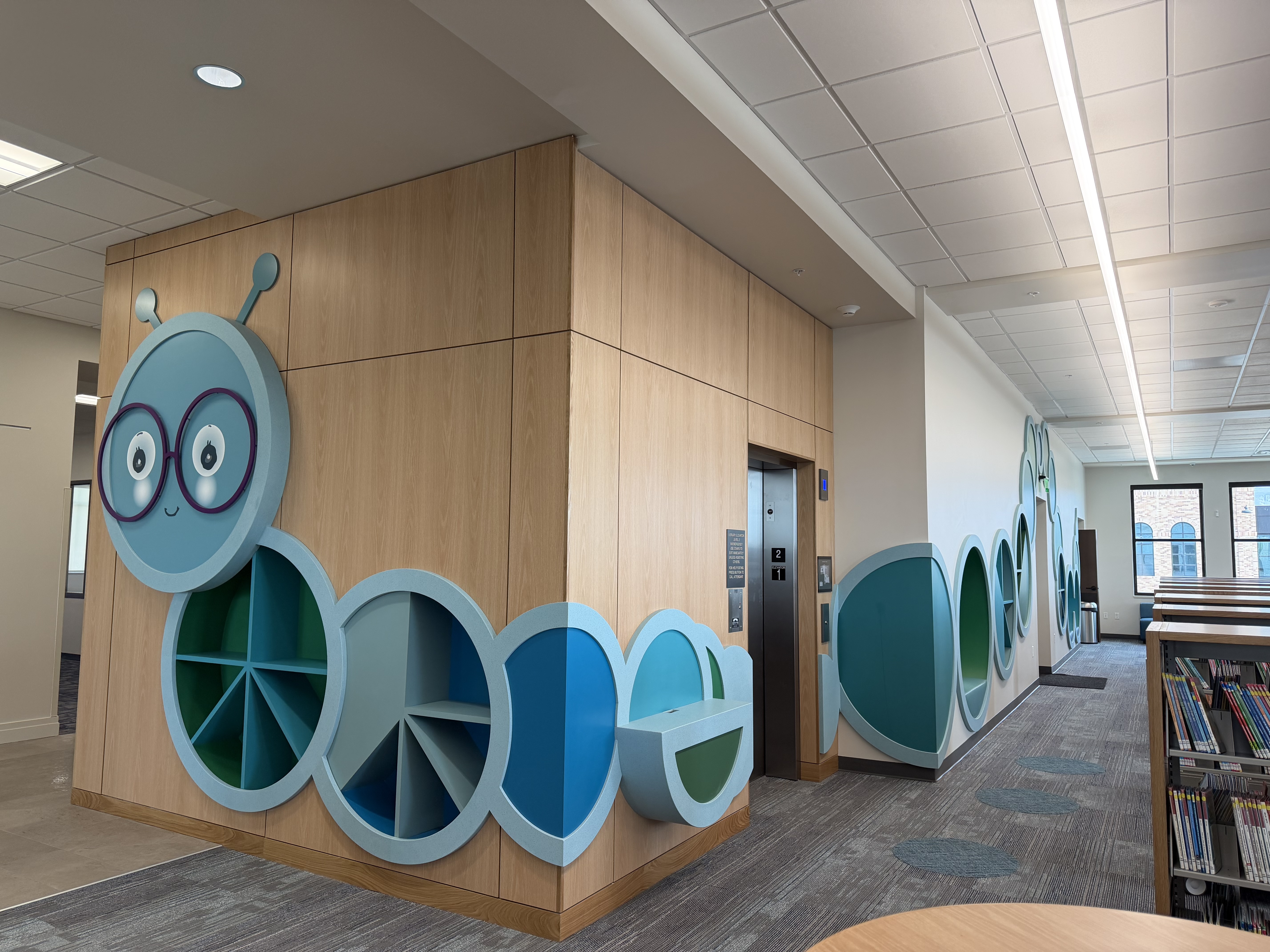 A decorative bookworm adorns the wall in the children's section of the new Lehi Library, located at the Lehi Civic Center, on Friday.