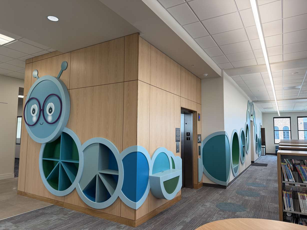 A decorative bookworm adorns the wall in the children's section of the new Lehi Library, located at the Lehi Civic Center, on Friday.