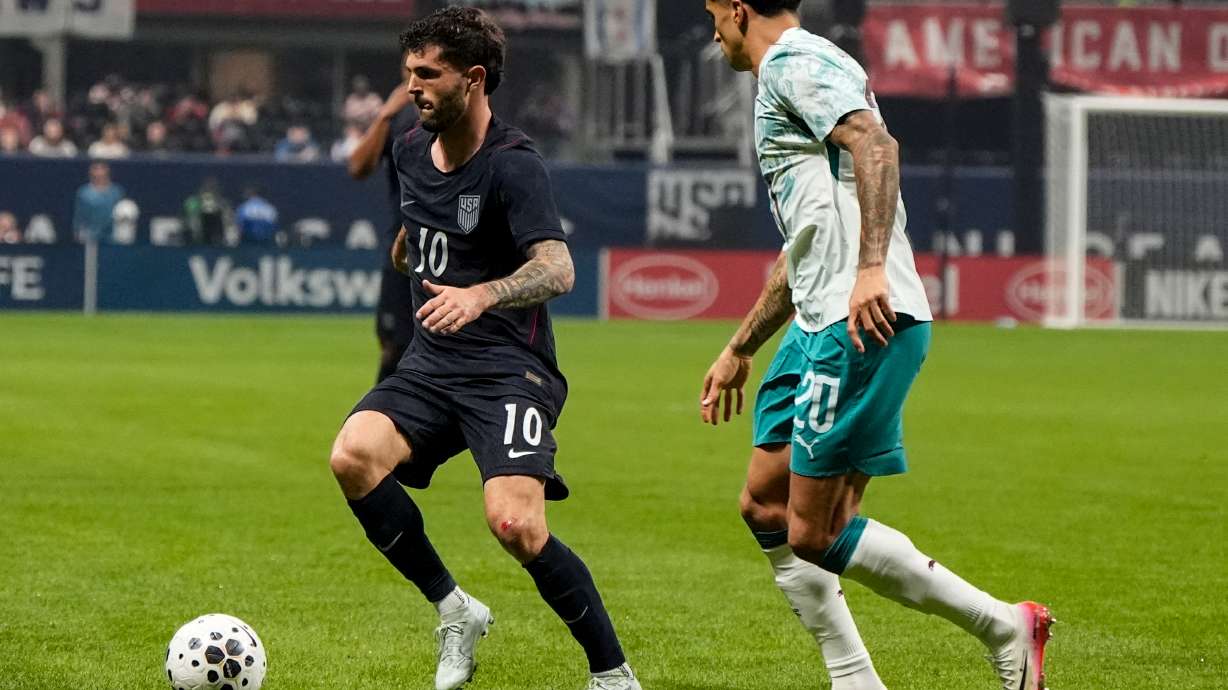 USA's Christian Pulisic (10) moves against Portugal's Joao Cancelo during the first half of an international friendly soccer match, Tuesday, March 31, 2026, in Atlanta.