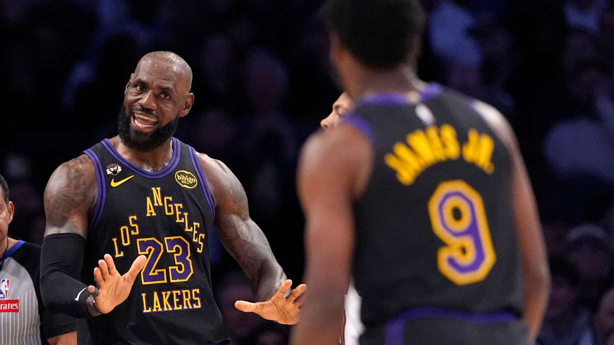 Los Angeles Lakers forward LeBron James, left, talks to guard Bronny James during the first half of an NBA basketball game against the Cleveland Cavaliers, Tuesday, March 31, 2026, in Los Angeles.