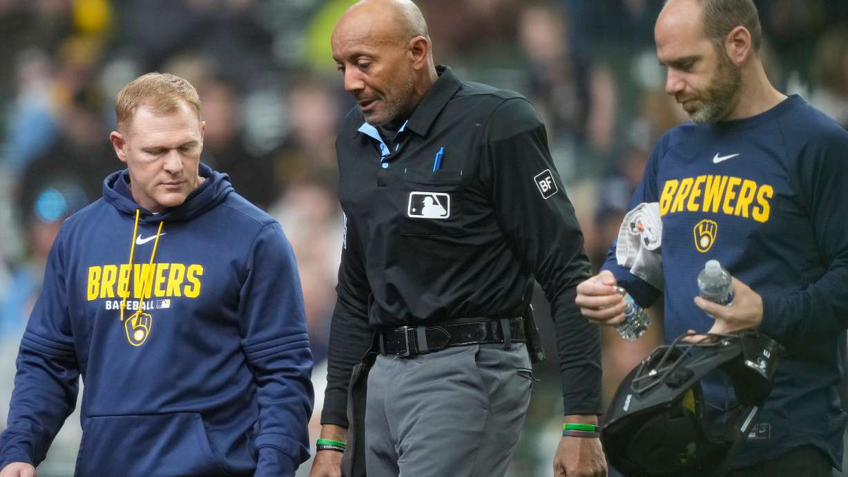 Major League Baseball umpire CB Bucknor, center, exits the game after being hit by a foul ball during the second inning of a baseball game between the Milwaukee Brewers and the Tampa Bay Rays, Wednesday, April 1, 2026, in Milwaukee.