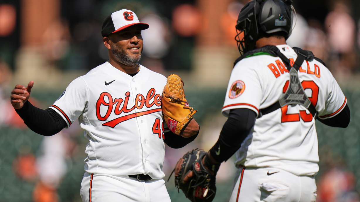Baltimore Orioles pitcher Albert Suarez, left, and catcher Samuel Basallo, right, celebrate their team's victory over the Texas Rangers after a pitch call was overturned through the Automated Ball-Strike system in the ninth inning of a baseball game, Wednesday, April 1, 2026, in Baltimore.