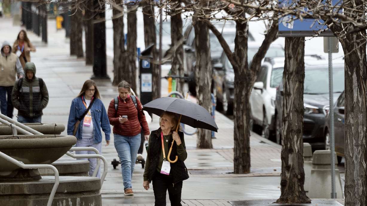 People walk through a light snow shower in Salt Lake City on March 6. More rain and snow are forecast to hit the Wasatch Front and northern Utah on Thursday, after a dry stretch was snapped on Wednesday.