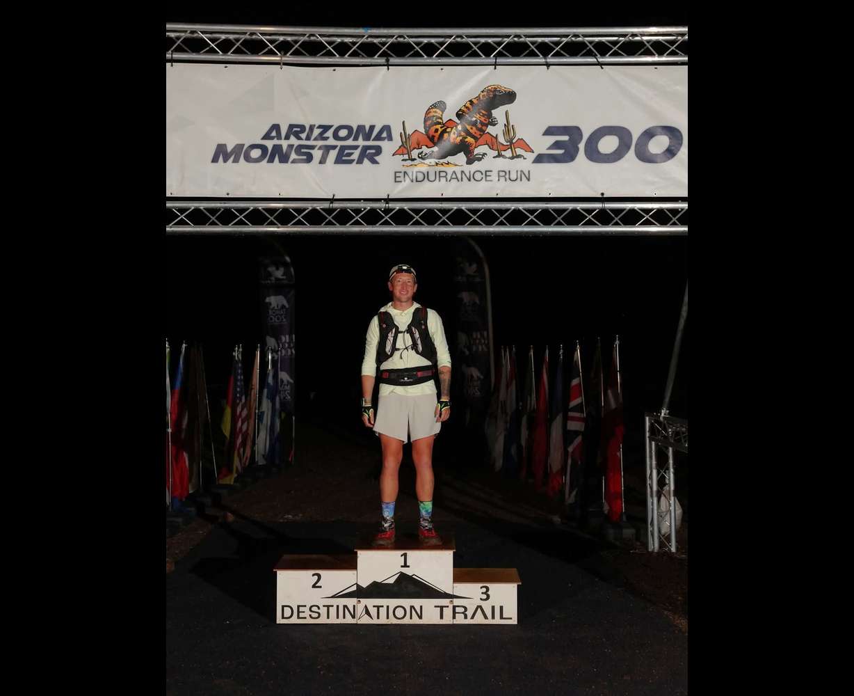 Michael McKnight stands alone on the podium after finishing the Arizona Monster 300 in record-time. A Utah native, McKnight overcame both mental and physical hurdles to break the record for the 304-mile race through the Sonoran Desert.