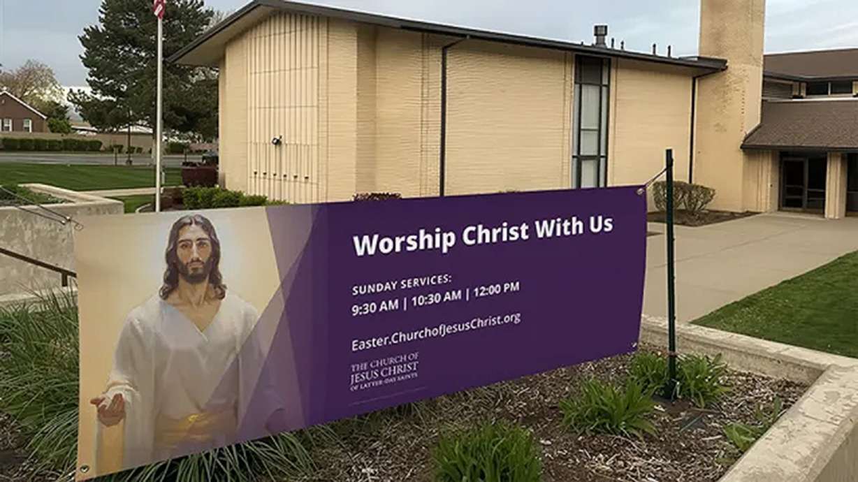 A chapel of The Church of Jesus Christ of Latter-day Saints advertises its Palm Sunday services on a sign as part of the "greater love" initiative.