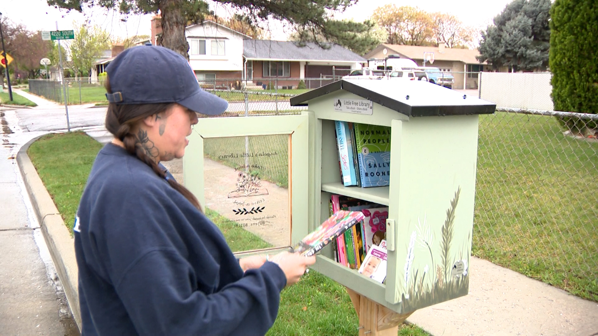 Angela Jensen in front of her "Little Free Library" in West Valley City, Wednesday. Jensen is hoping donations will continue after a man cleared out her library on Tuesday.