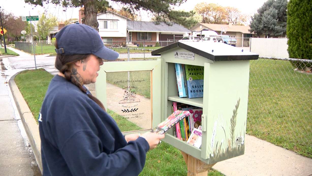 Angela Jensen in front of her "Little Free Library" in West Valley City, Wednesday. Jensen is hoping donations will continue after a man cleared out her library on Tuesday.