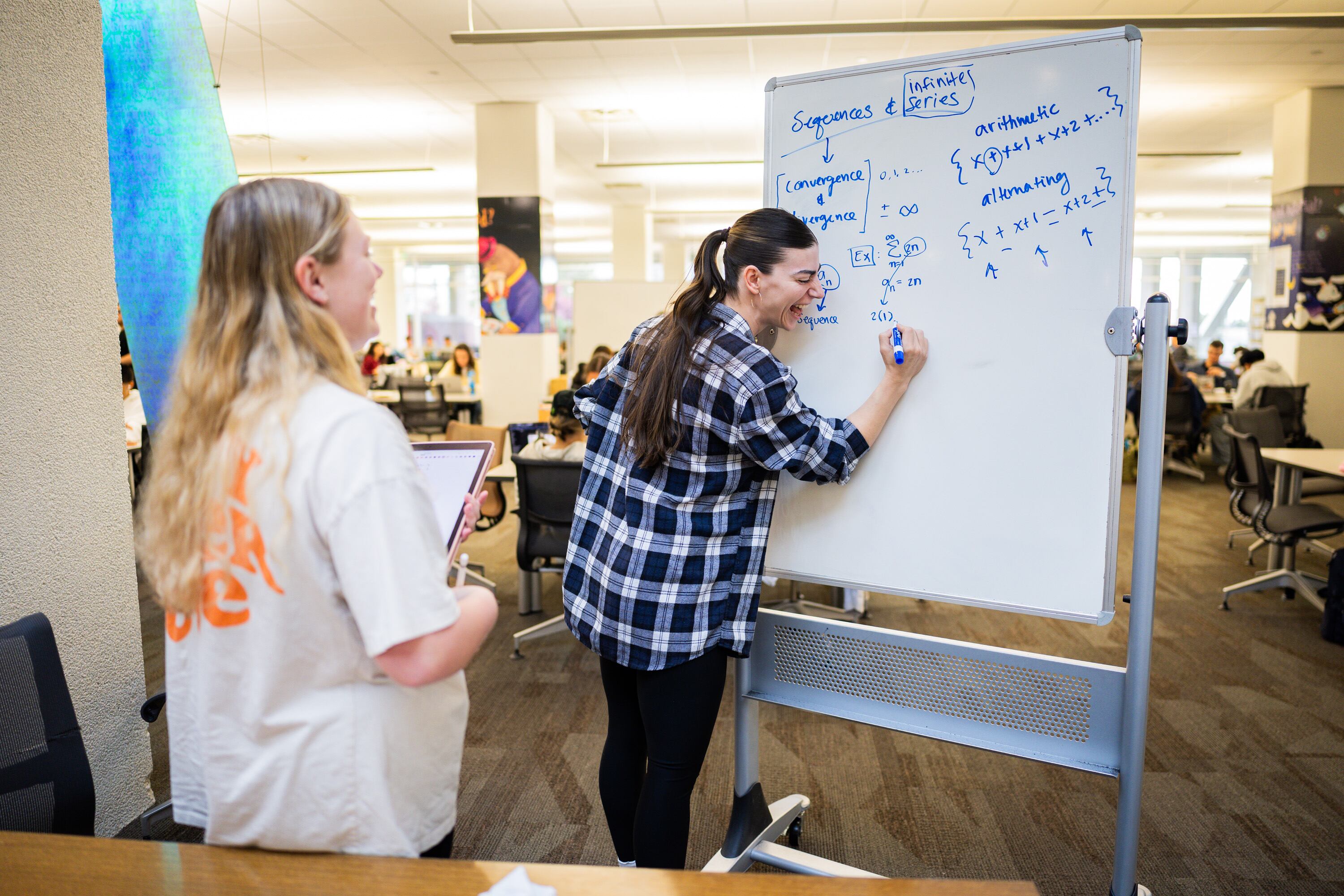 University of Utah student Jadyn Littlefield, 23, left, is tutored by University of Utah student Sarah Heywood, 33, right, at the J. Willard Marriott Library  in Salt Lake City on Wednesday.