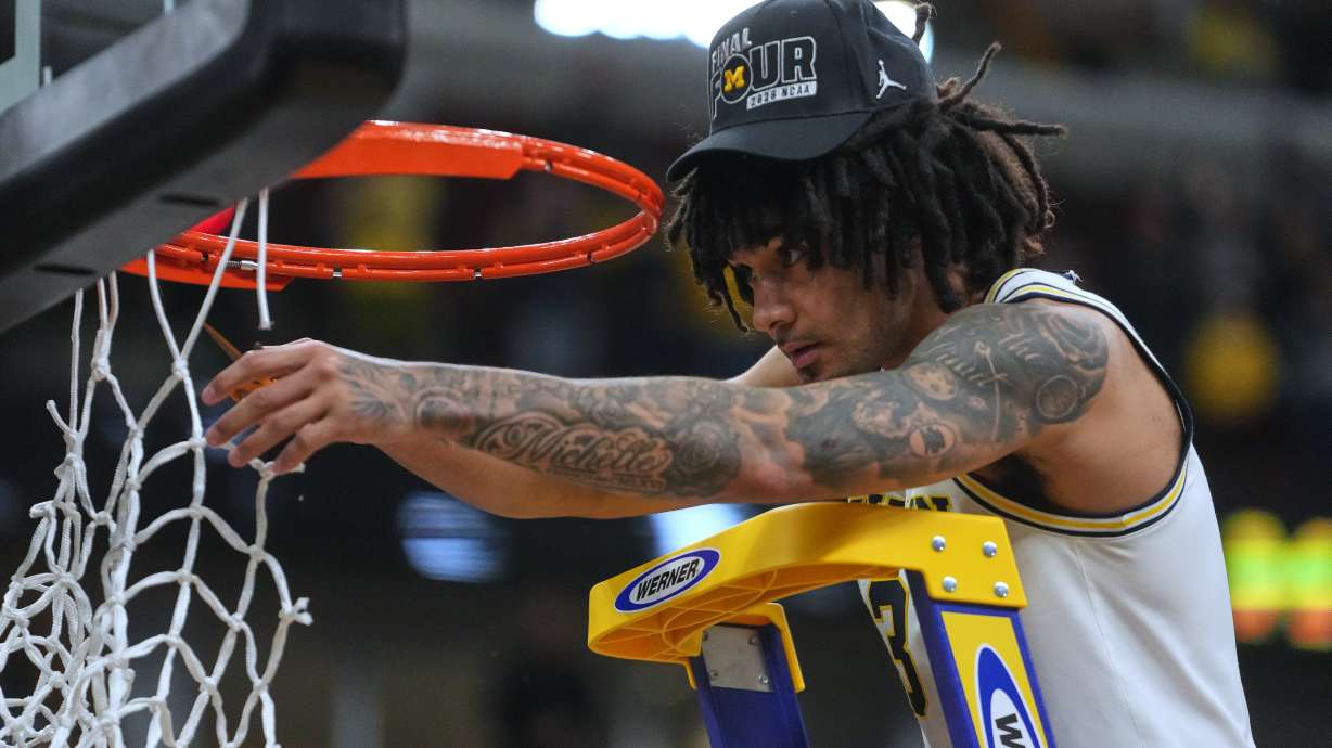 Michigan's Elliot Cadeau celebrates by cutting down the net after defeating Tennessee in the Elite Eight of the NCAA college basketball tournament, Sunday, March 29, 2026, in Chicago.
