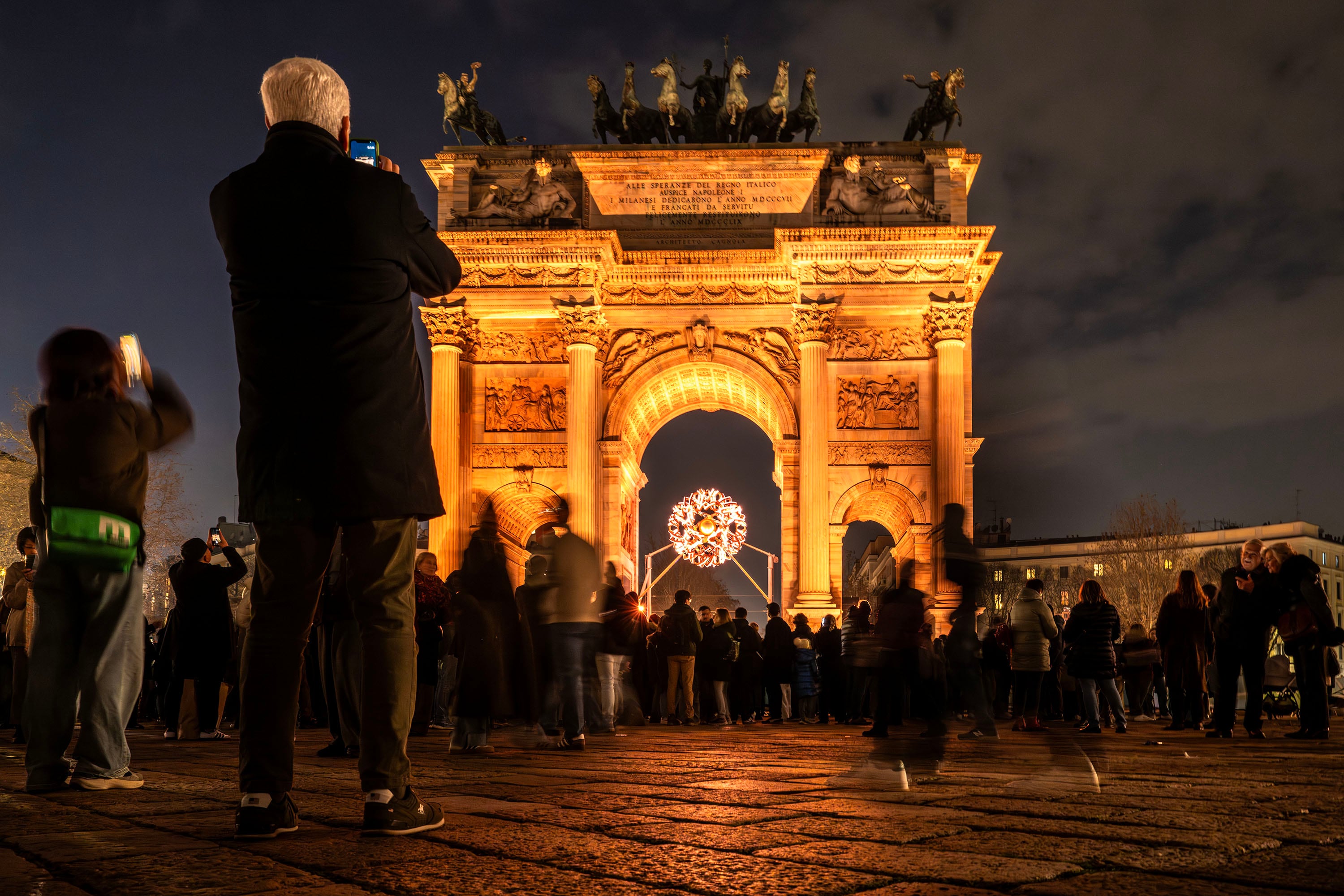 Visitors take photos at the Olympic cauldron of the 2026 Milan Cortina Winter Olympics at the Arco della Pace in Milan, Italy, on Saturday, Feb. 7, 2026.