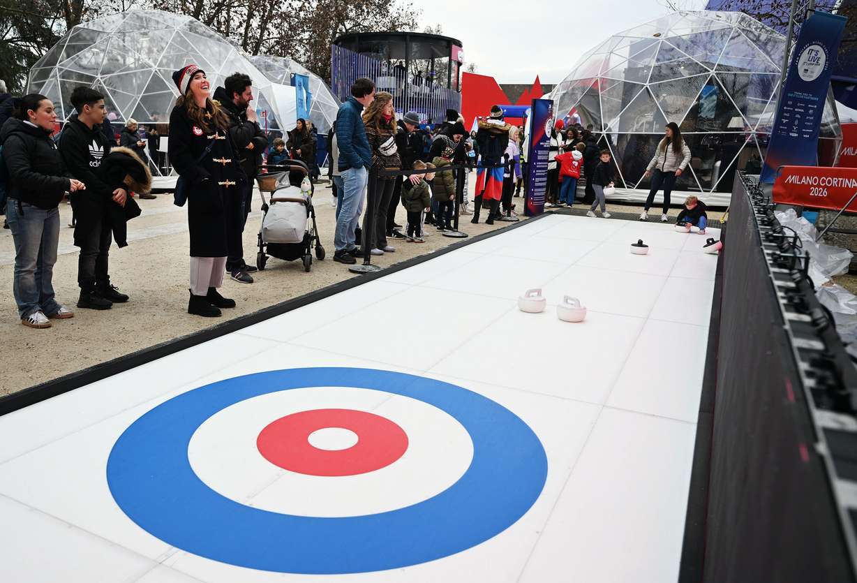 Salt Lake City Mayor Erin Mendenhall, laughs as she watches kids try Curling at the Olympic fan in Milan, Italy, on Feb. 11.