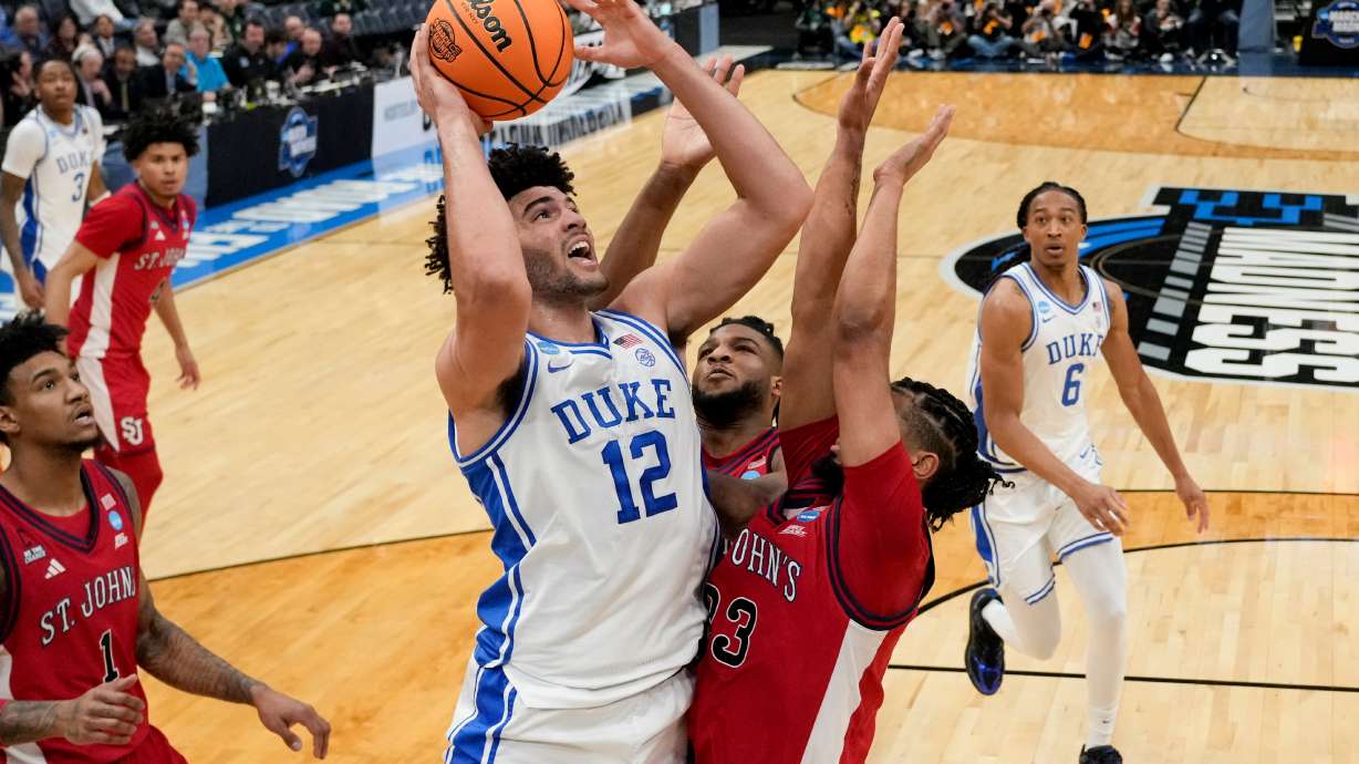 Duke forward Cameron Boozer (12) shoots over St. John's forward Bryce Hopkins (23) during the first half in the Sweet 16 of the NCAA college basketball tournament, Friday, March 27, 2026, in Washington.