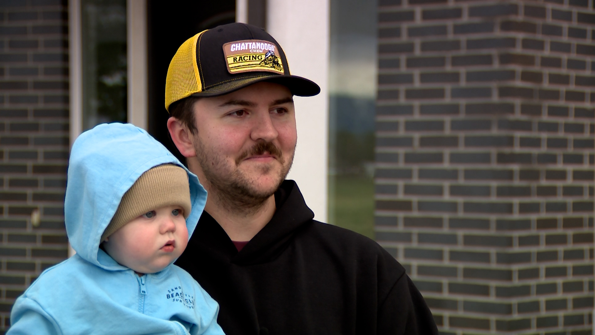 Braden Christensen speaks with KSL Thursday in Lehi while holding his son, Baker.