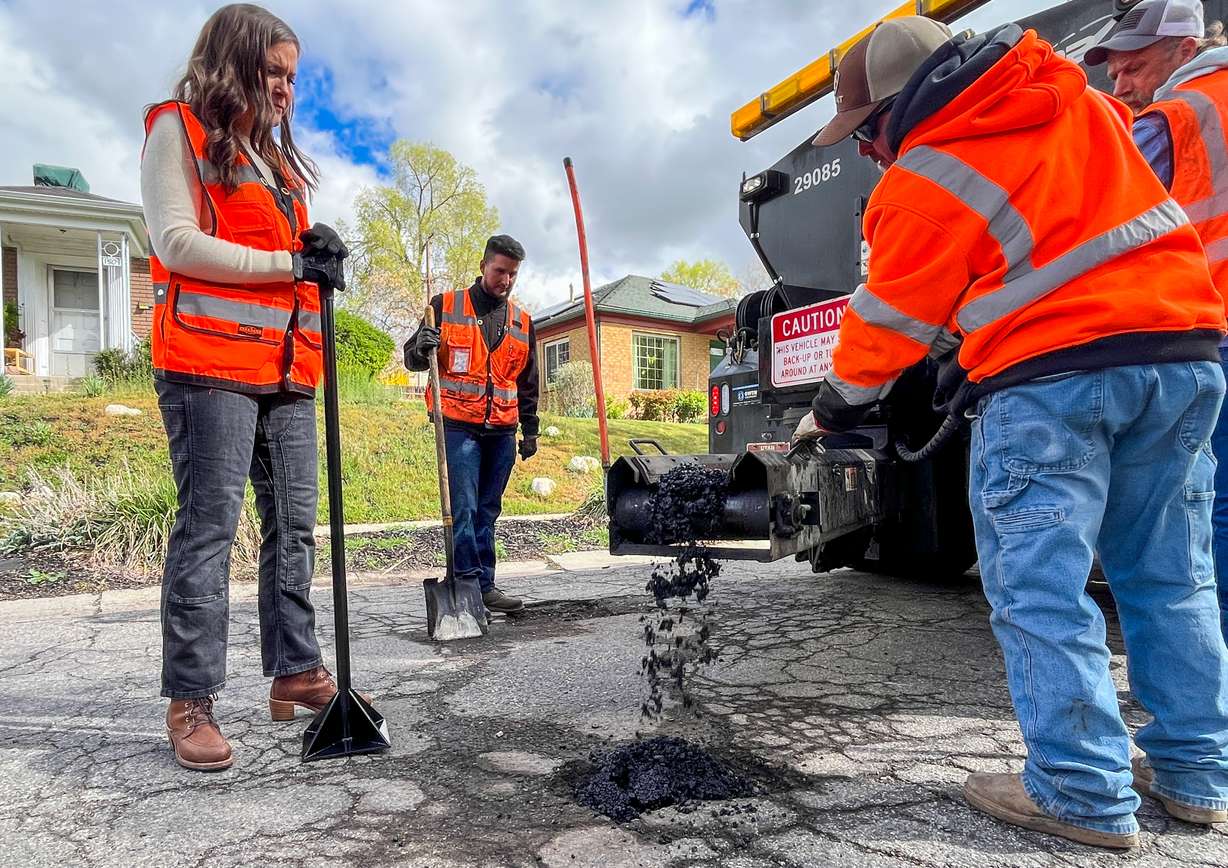 Salt Lake City Mayor Erin Mendenhall watches as city streets employees fill an asphalt mix to fill a pothole in Salt Lake City's Sugar House neighborhood on Friday. The city will hold its annual "Pothole Palooza" next week, filling as many potholes as possible on city streets.