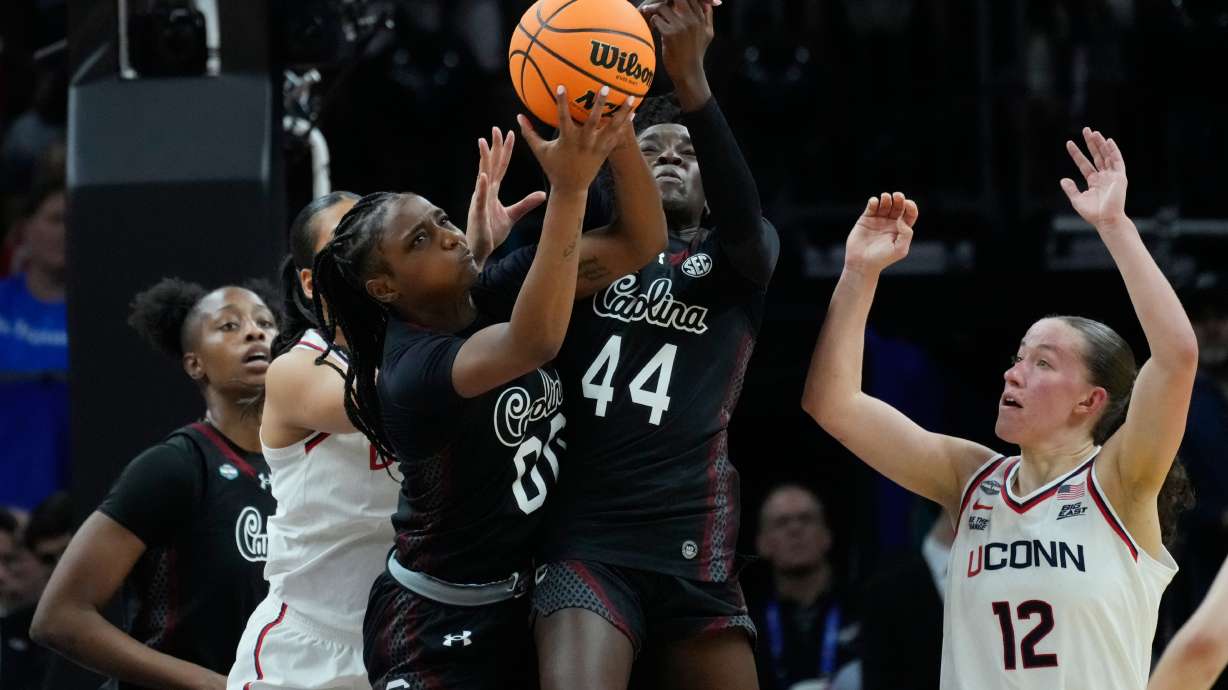 South Carolina guard Ta'Niya Latson (00) and South Carolina guard Agot Makeer (44) go for a rebound against UConn during the first half of a woman's NCAA college basketball tournament semifinal game at the Final Four, Friday, April 3, 2026, in Phoenix.