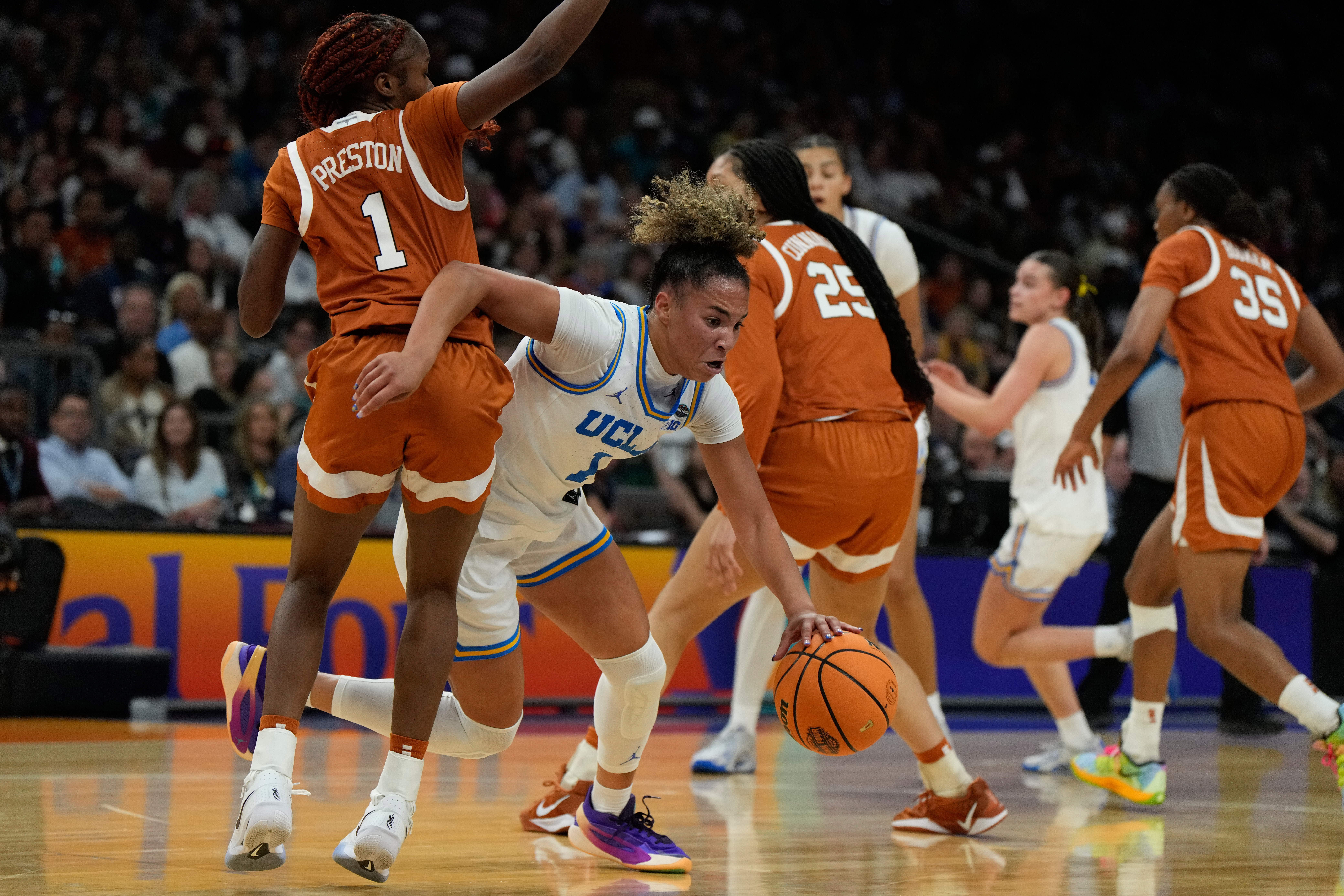 UCLA guard Kiki Rice (1) drives against Texas guard Bryanna Preston, left, during the first half of a women's NCAA college basketball tournament semifinal game at the Final Four, Friday, April 3, 2026, in Phoenix.