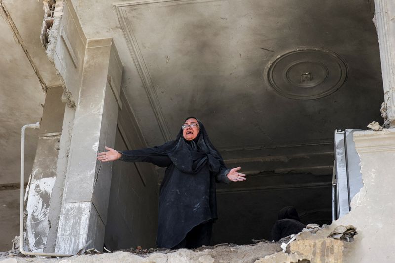 A woman reacts inside her brother's home, which was damaged by an airstrike, in Tehran, Iran, March 30.