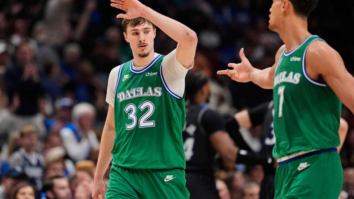 Dallas Mavericks forward Cooper Flagg (32) and Dwight Powell, right, celebrate a basket by Flagg in the second half of an NBA basketball game against the Orlando Magic Friday, April 3, 2026, in Dallas.