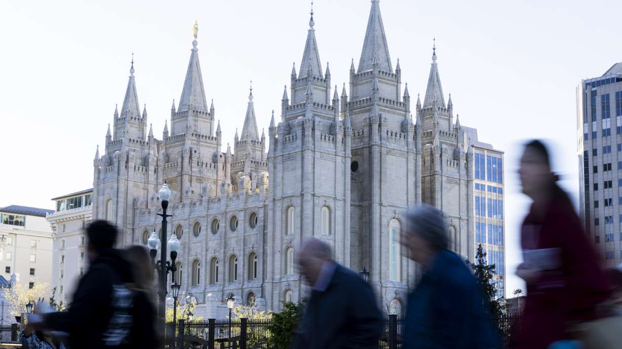 Conferencegoers walk near the Salt Lake Temple before the Saturday morning session of general conference of The Church of Jesus Christ of Latter-day Saints in Salt Lake City on Saturday.
