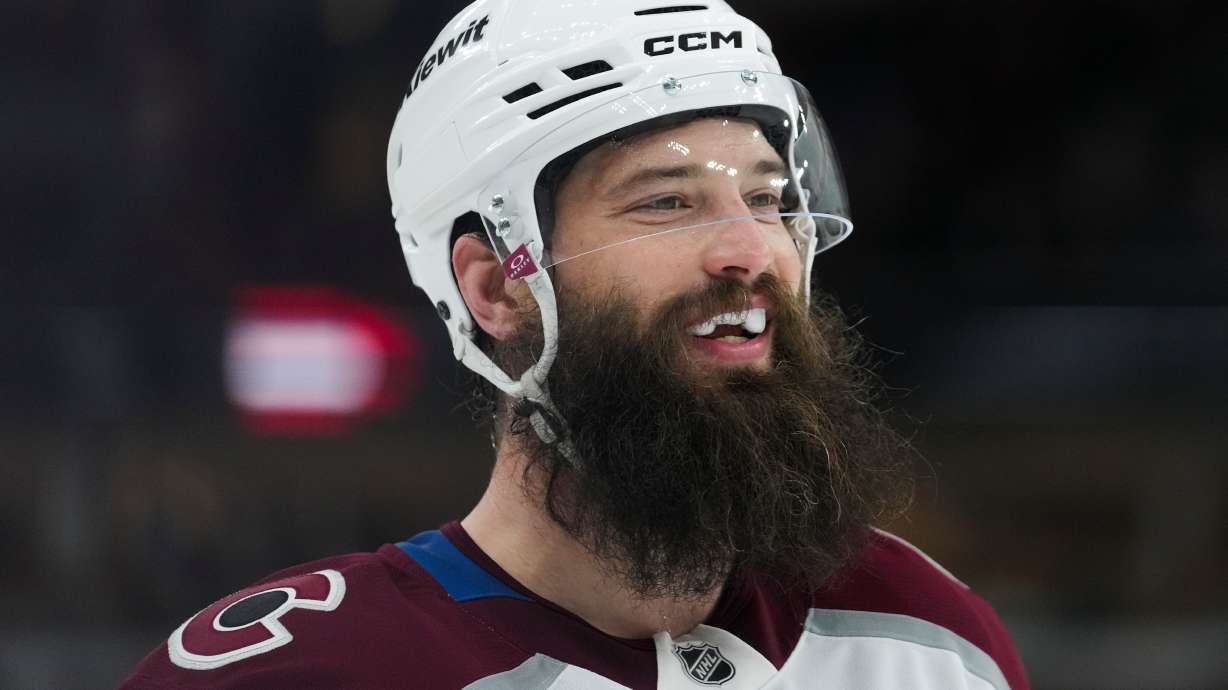 Colorado Avalanche defenseman Brent Burns (84) smiles at his teammates at the end of the first period of an NHL hockey game against the Chicago Blackhawks, Friday, March 20, 2026, in Chicago.