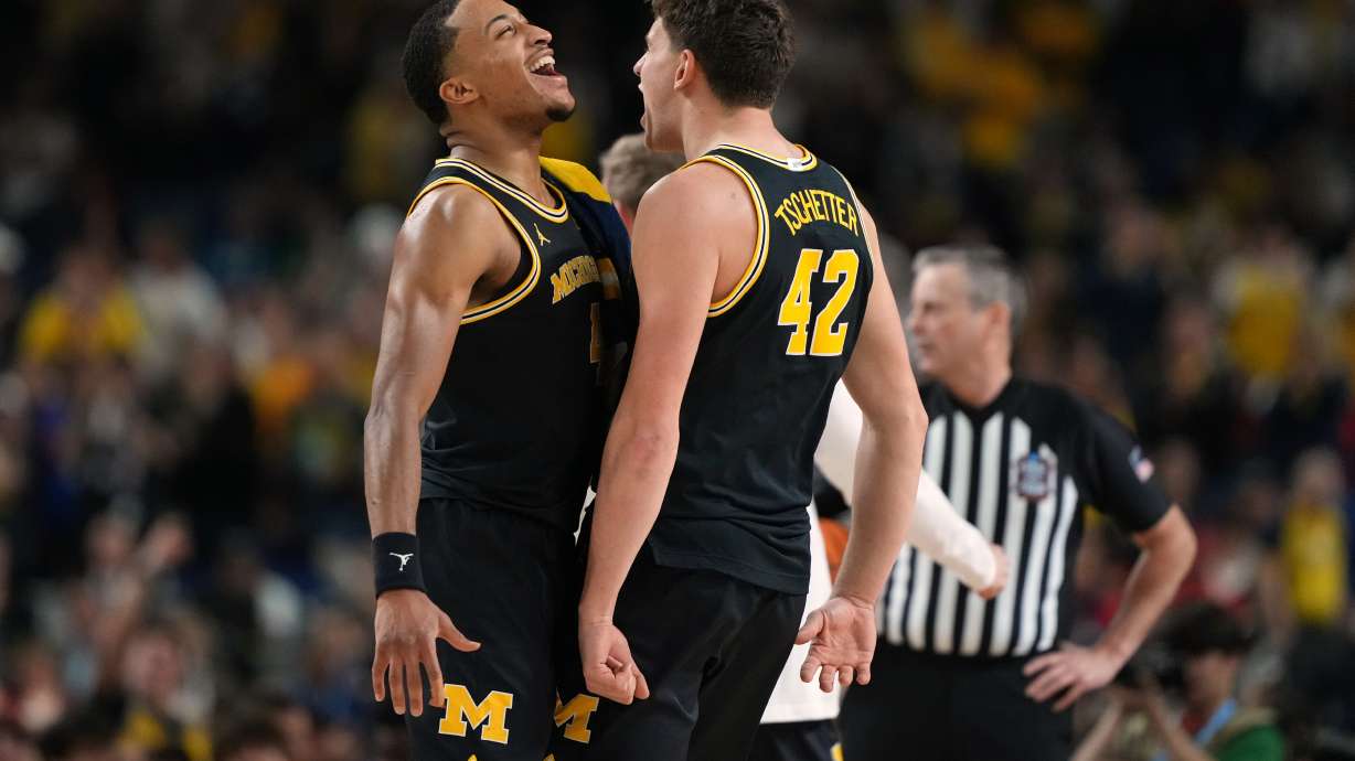 Michigan's Nimari Burnett, left, and Will Tschetter (42) celebrate during the second half of an NCAA college basketball tournament semifinal game against Arizona at the Final Four, Saturday, April 4, 2026, in Indianapolis.