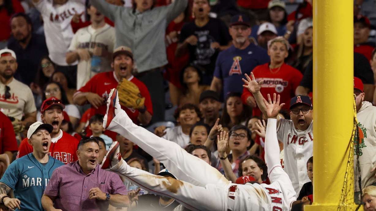 Los Angeles Angels left fielder Jo Adell (7) catches a ball hit by Seattle Mariners' J.P. Crawford during the ninth inning of a baseball game Saturday in Anaheim, Calif. Adell robbed three home runs in the game.