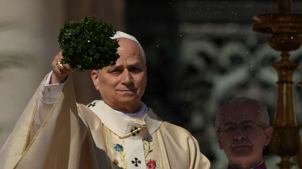 Pope Leo XIV sprinkles holy water with a bunch of hyssop sprigs as he presides over Easter Mass in St. Peter’s Square at the Vatican, Sunday.
