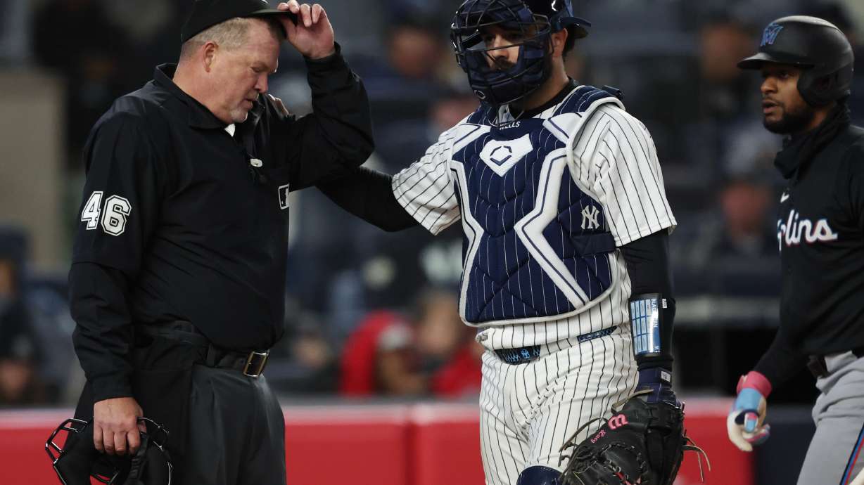 New York Yankees catcher Austin Wells (28) checks on home plate umpire Ron Kulpa during the fourth inning of a baseball game against the Miami Marlins, Saturday, April 4, 2026, in New York.