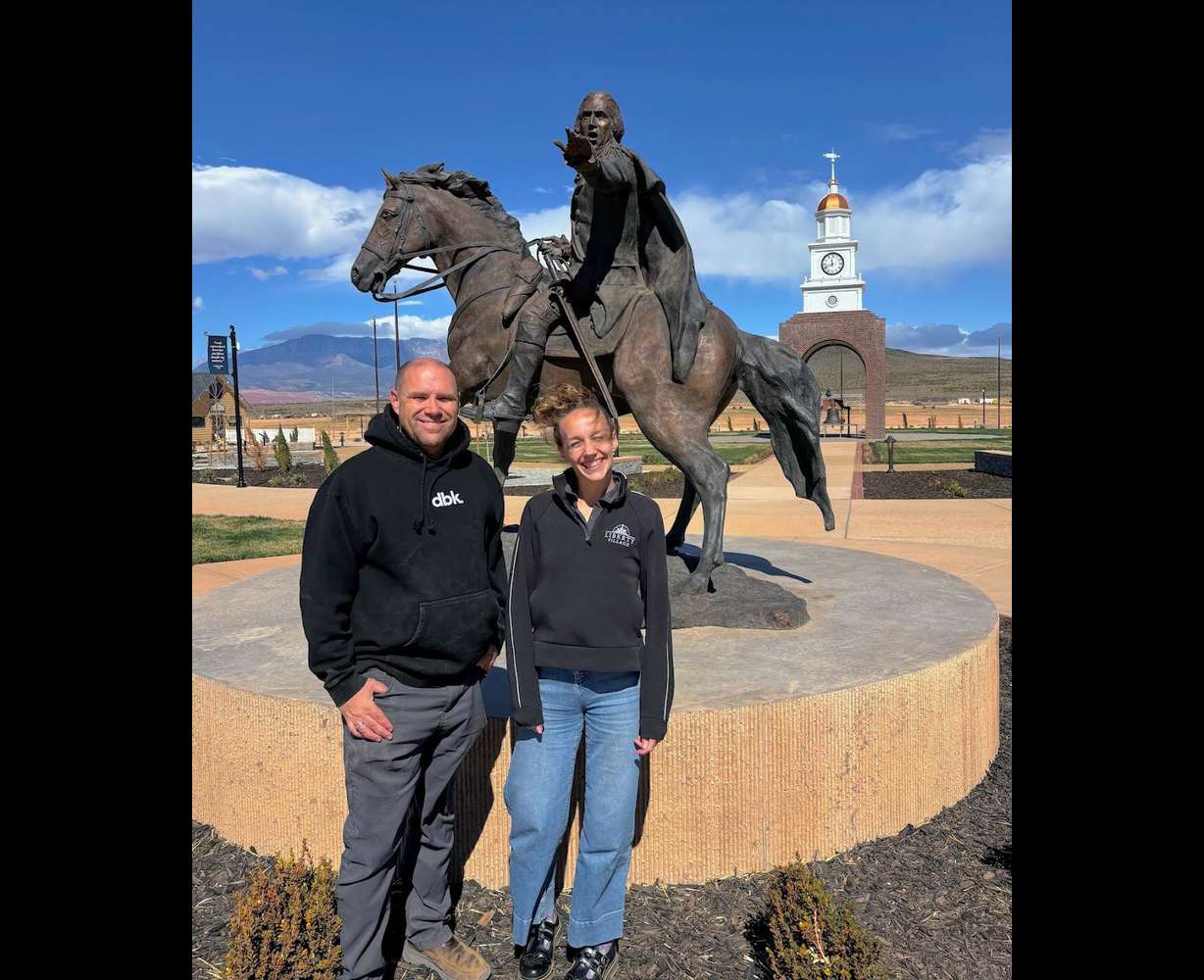 Richard LeBaron, director of operations, and Ellen Jensen, director of marketing, stand in front of a sculpture of George Washington at Liberty Village in Hurricane, Washington County.
