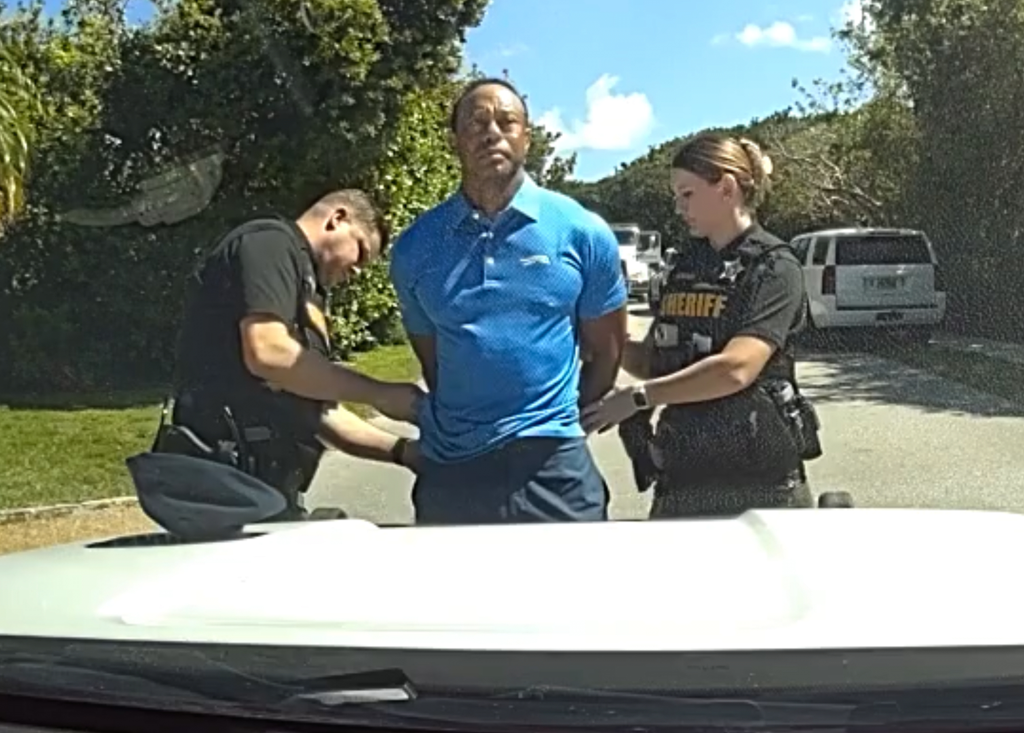 In this image from police body camera video released by the Martin County, Fla., Sheriff's Office, golfer Tiger Woods is taken into custody by sheriff's deputies following a car crash in Jupiter Island, Fla., Friday, March 27, 2026.