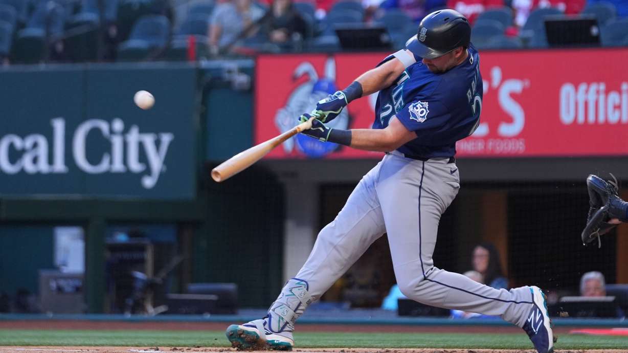 Seattle Mariners' Cal Raleigh connects on a solo home run off Texas Rangers starting pitcher Jacob deGrom during the first inning of a baseball game Monday, April 6, 2026, in Arlington, Texas.