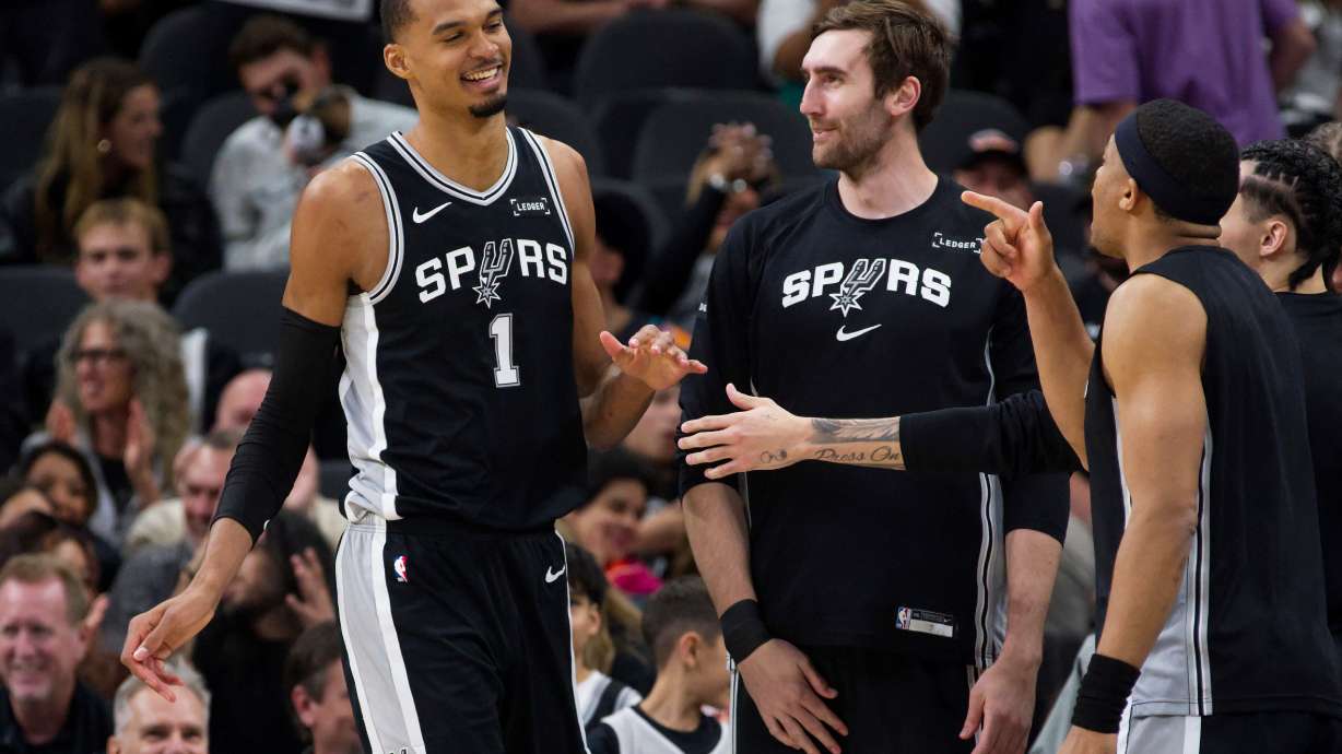 San Antonio Spurs center Victor Wembanyama (1) celebrates a basket with teammates Luke Kornet and Keldon Johnson, right, during the first half of their NBA basketball game against the Philadelphia 76ers, Monday, April 6, 2026, in San Antonio.