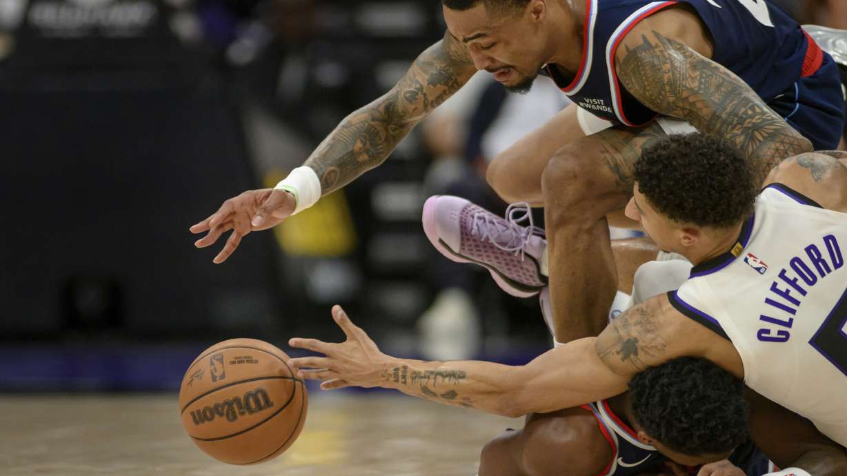 Los Angeles Clippers forward John Collins, top, and guard Bennedict Mathurin, bottom, battle for a loose ball with Sacramento Kings guard Nique Clifford during the second half of an NBA basketball game in Sacramento, Calif., Sunday, April 5, 2026.