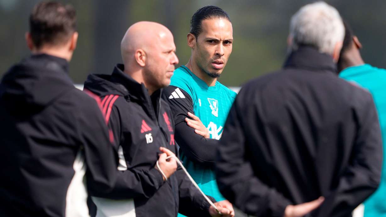Liverpool's Virgil van Dijk, center, and manager Arne Slot, second left, attend a training session in Liverpool, England, Tuesday April 7, 2026.