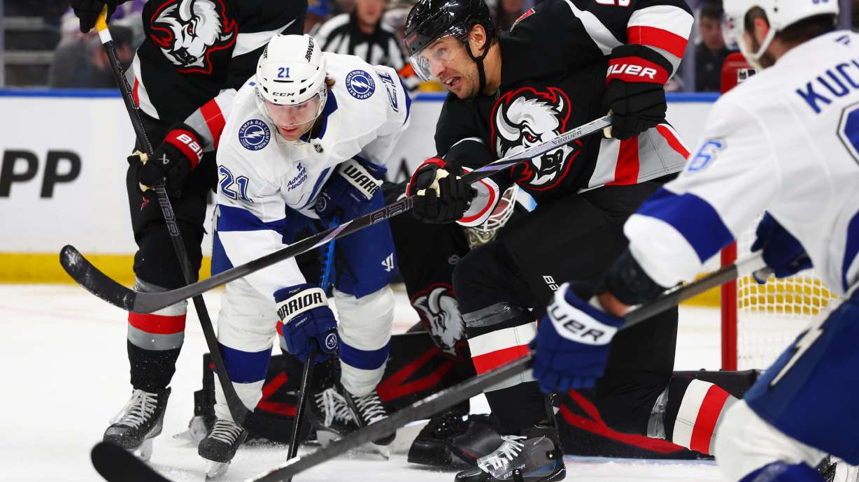 Buffalo Sabres defenseman Luke Schenn (5) clears the puck in front of Tampa Bay Lightning center Brayden Point (21) during the second period of an NHL hockey game Monday, April 6, 2026, in Buffalo, N.Y.
