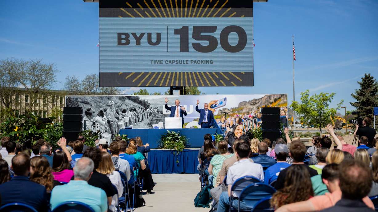 BYU president Shane Reese and Keith Vorkink, BYU’s advancement vice president, speak during a time capsule packing party as part of BYU’s 150th anniversary celebration at Brigham Square in Provo on Tuesday. The capsule will be opened in 2075.