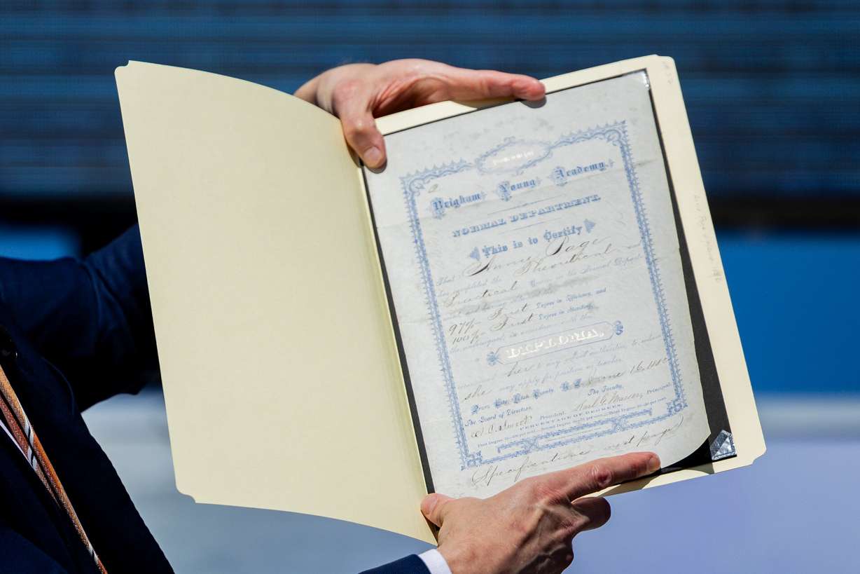 Keith Vorkink, BYU’s advancement vice president, holds up a diploma before putting it in a time capsule during a time capsule packing party as part of BYU’s 150th anniversary celebration at Brigham Square in Provo on Tuesday. The capsule will be opened in 2075.
