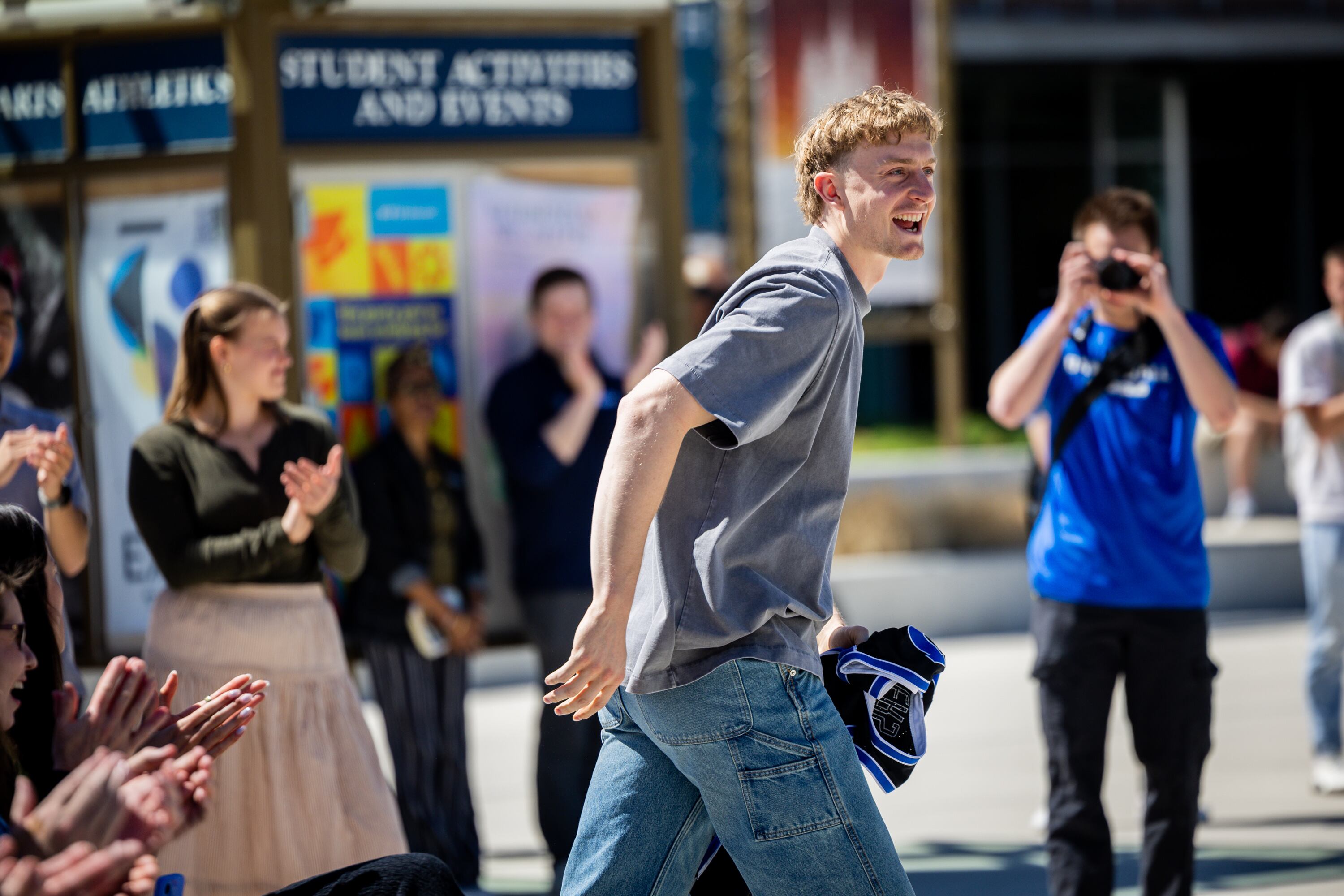 BYU basketball player Richie Saunders is welcomed onstage to put his jersey into a time capsule during a time capsule packing party as part of BYU’s 150th anniversary celebration at Brigham Square in Provo on Tuesday. Saunders joked he might be on the same path as Elder S. Gifford Nielsen, who also had his jersey in the opened time capsule.