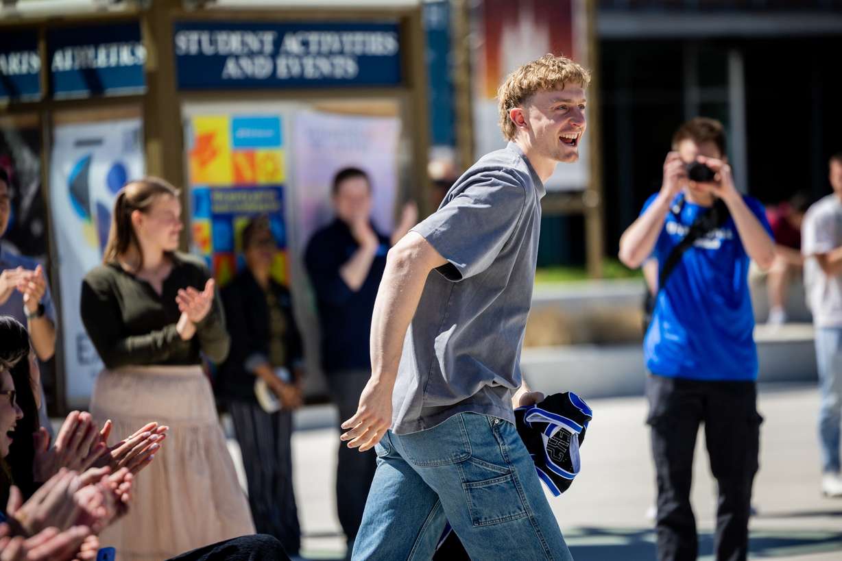 BYU basketball player Richie Saunders is welcomed onstage to put his jersey into a time capsule during a time capsule packing party as part of BYU’s 150th anniversary celebration at Brigham Square in Provo on Tuesday. Saunders joked he might be on the same path as Elder S. Gifford Nielsen, who also had his jersey in the opened time capsule.