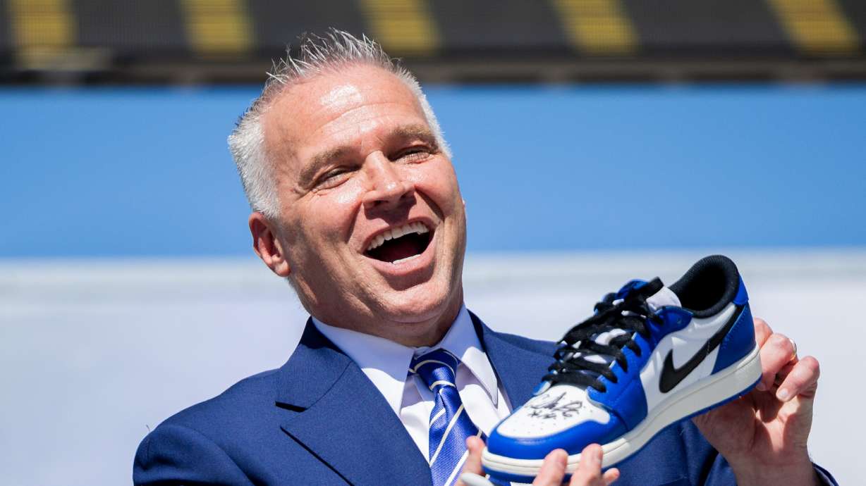 BYU President Shane Reese signs one of his shoes before putting it inside a time capsule during a time capsule packing party as part of BYU’s 150th anniversary celebration at Brigham Square on April 7. Reese has made it a point to foster connections in Mapleton by simply waving at others.