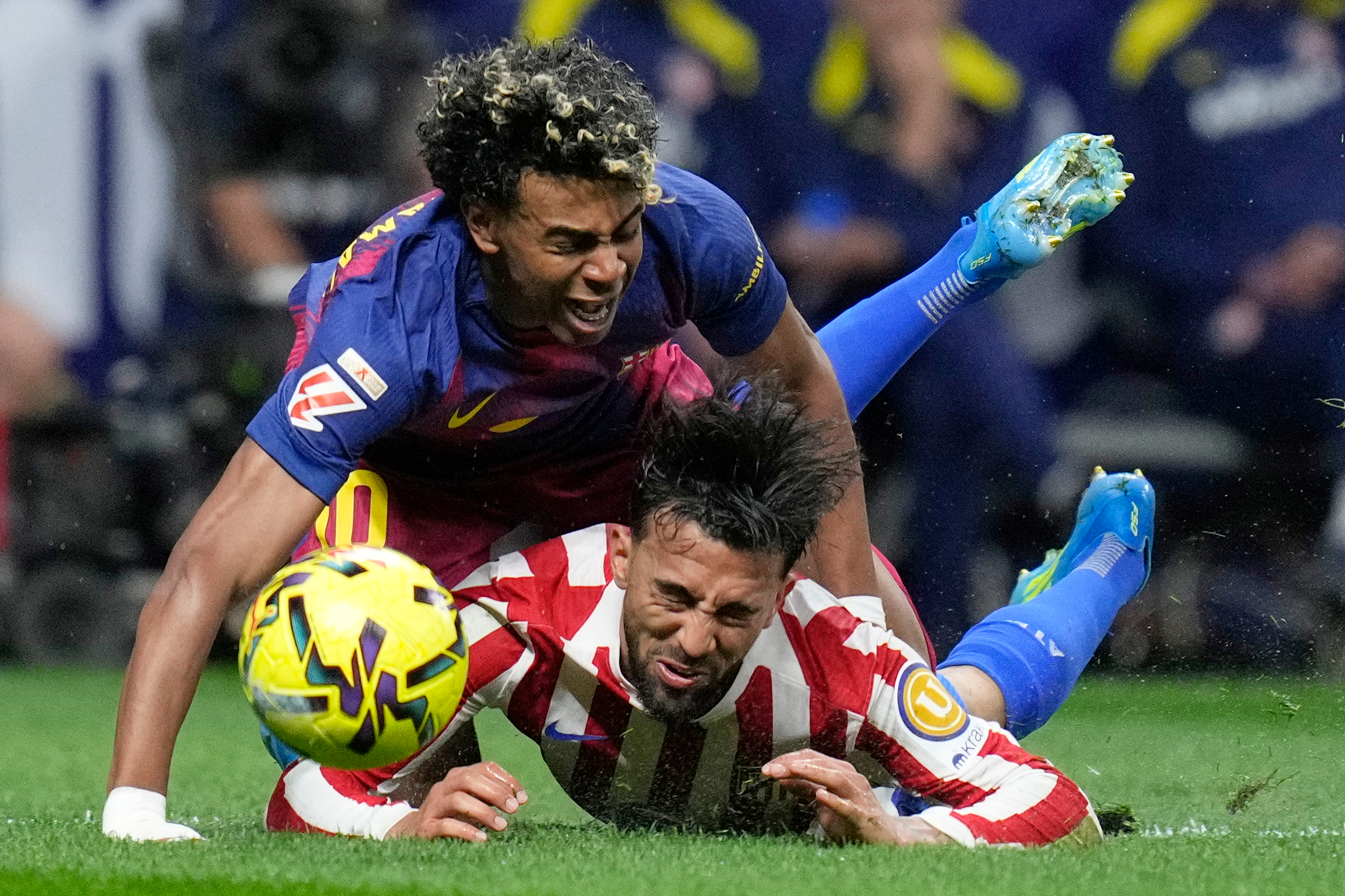 Barcelona's Lamine Yamal, top, is tackled and fouled by Atletico Madrid's Nico Gonzalez, who receives a second yellow card and is then sent off during a La Liga soccer match between Atletico Madrid and Barcelona in Madrid, Spain, Saturday, April 4, 2026. 