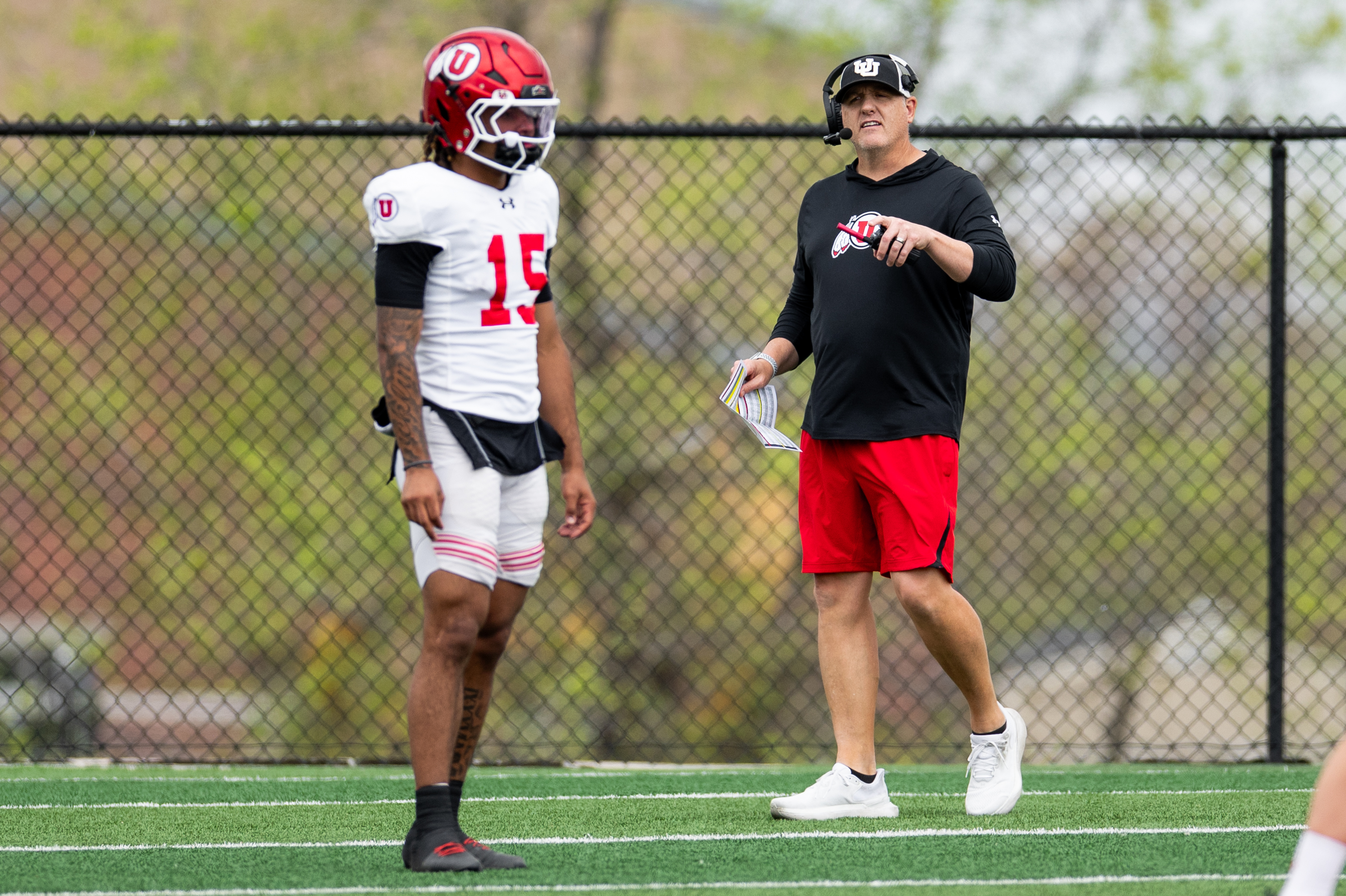 Sophomore quarterback Byrd Ficklin looks on as Utah offensive coordinator Kevin McGiven calls out a play during spring practice in Salt Lake City.