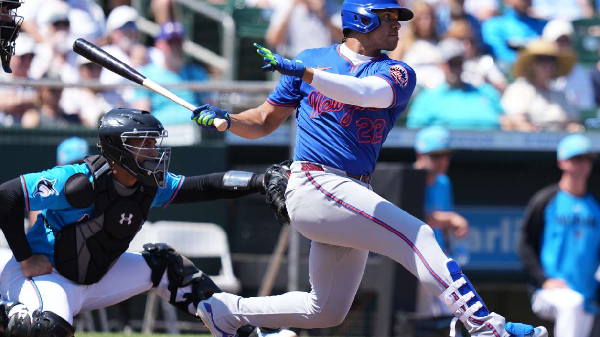 New York Mets' Juan Soto, right, hits a single during the fourth inning of a spring training baseball game against the Miami Marlins, Sunday, March 22, 2026, in Jupiter, Fla.