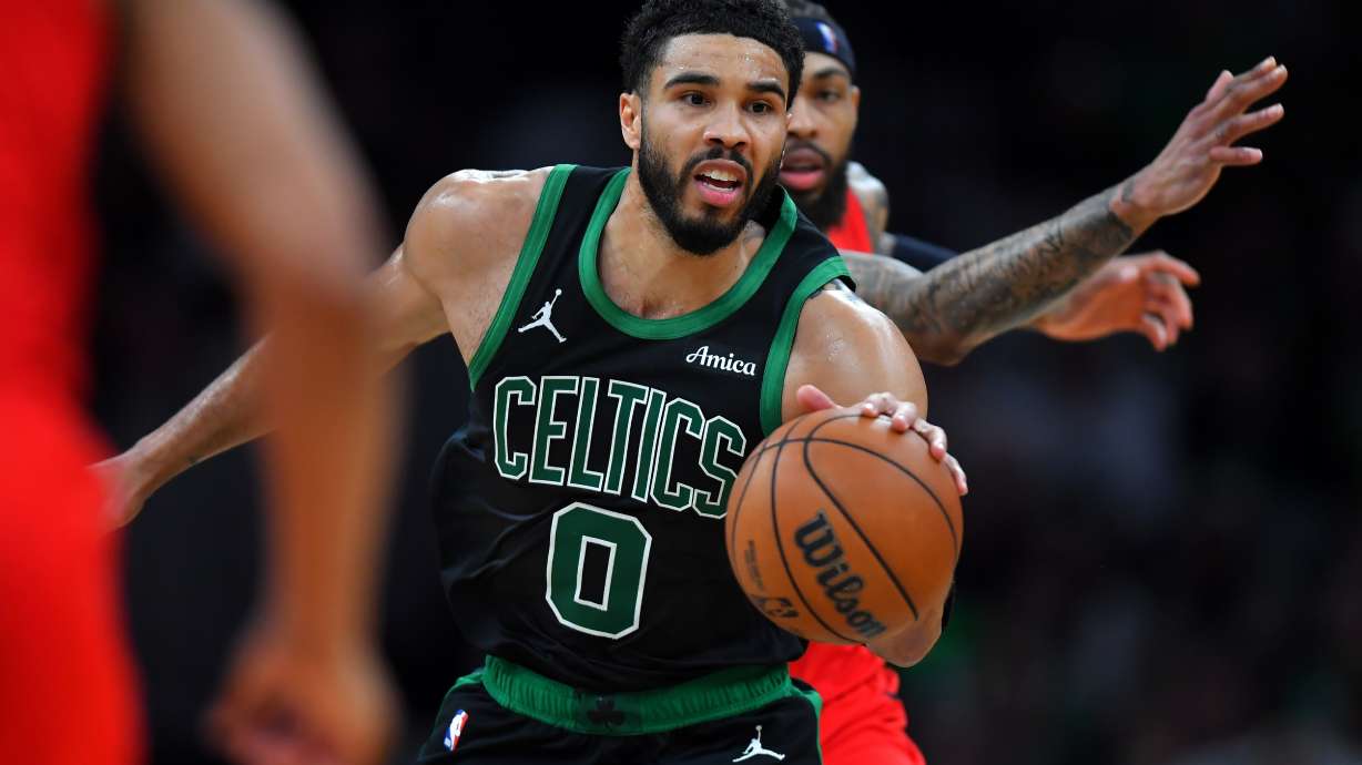 Boston Celtics forward Jayson Tatum (0) drives with the ball in front of Toronto Raptors forward Brandon Ingram in the second half of an NBA basketball game, Sunday, April 5, 2026, in Boston.